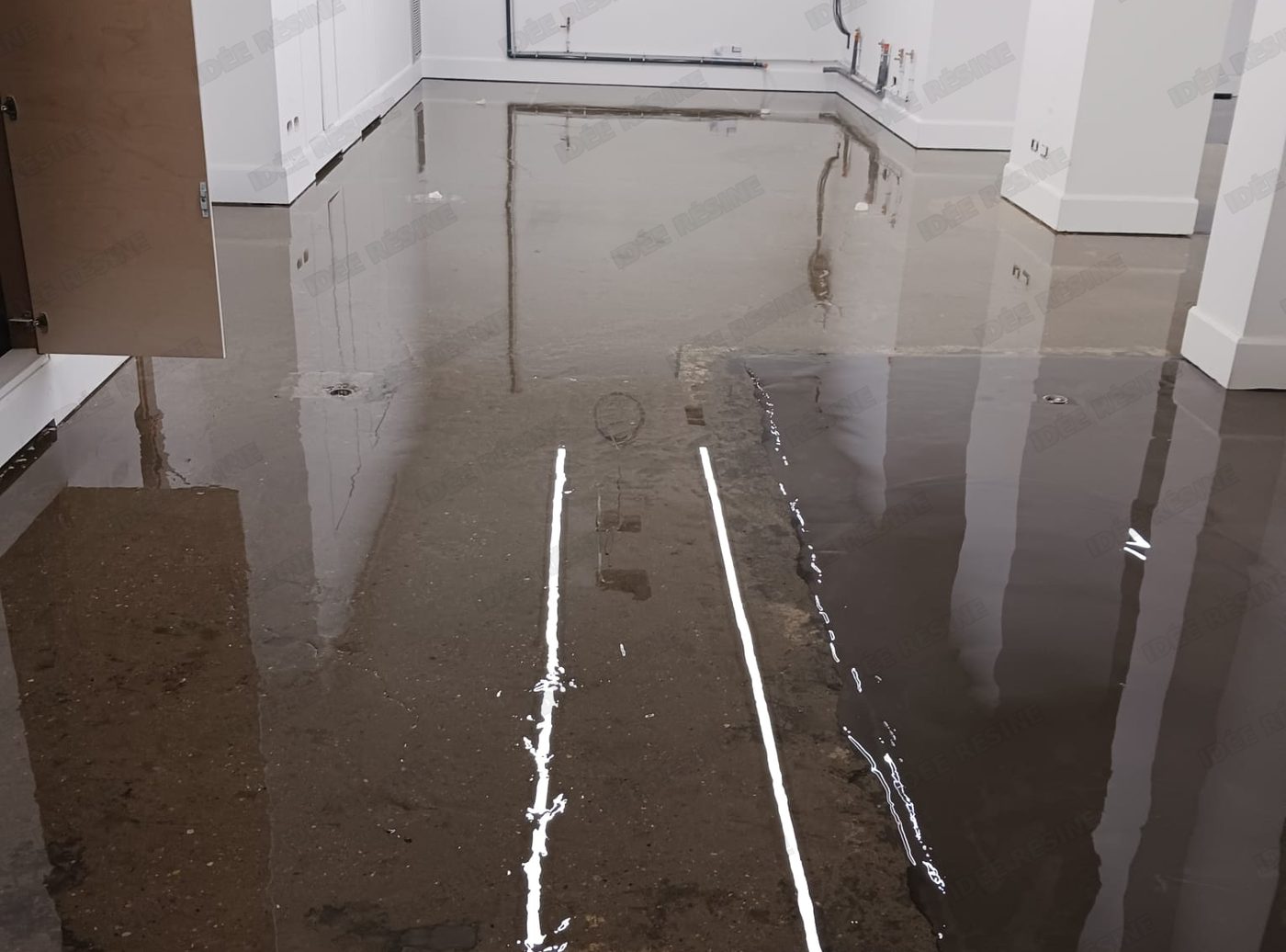 Application d’un système de résine autolissante sur un sol, chantier réel Idée Résine
